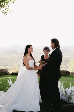 Wedding ceremony photos showing a couple exchanging vows outdoors with scenic mountain views in the background.