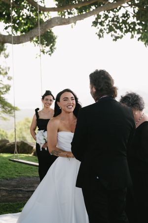 A joyful wedding celebration moment captured outdoors under tree branches.