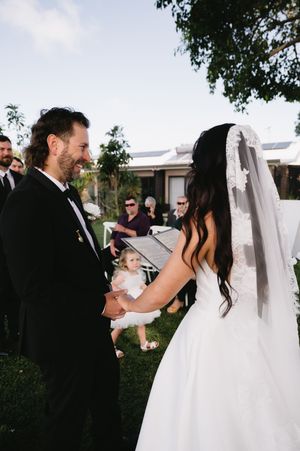 Outdoor wedding ceremony with couple exchanging vows surrounded by loved ones.