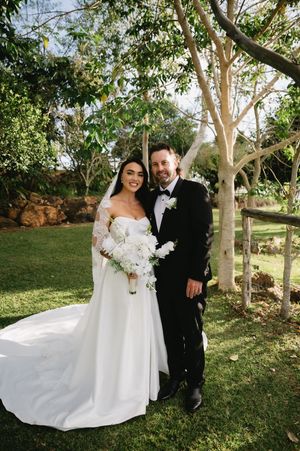 Romantic wedding portraits captured in a lush garden setting with natural lighting.