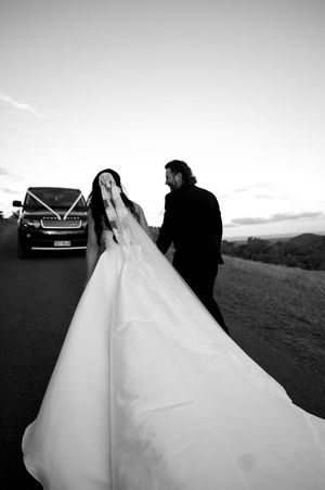 Black and white wedding photos showing dramatic dress silhouettes against sunset sky.