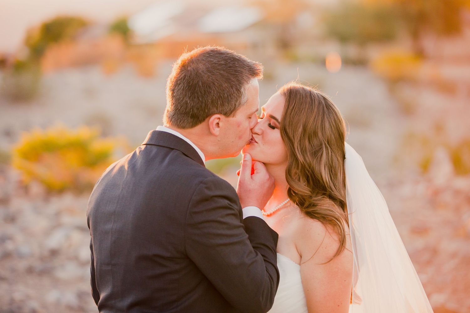 Romantic sunset wedding photo series showing tender moments between newlyweds in warm golden light.
