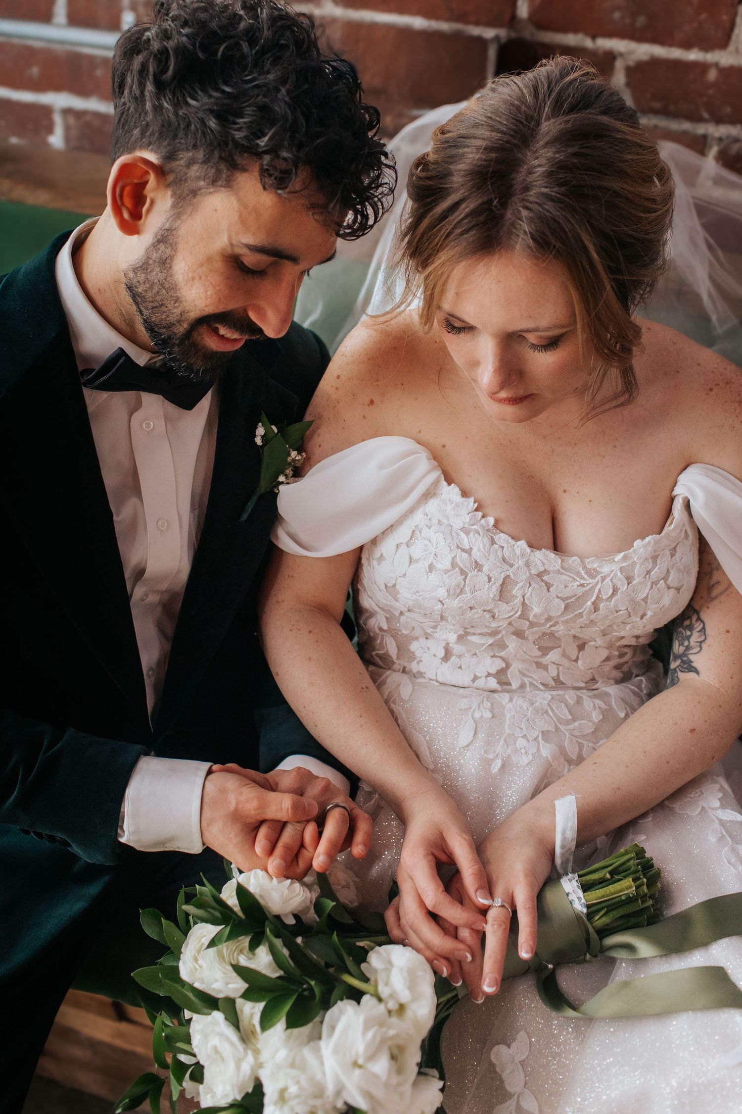 Close-up detail shots of couple's hands and wedding attire showing white floral dress details and romantic moments.