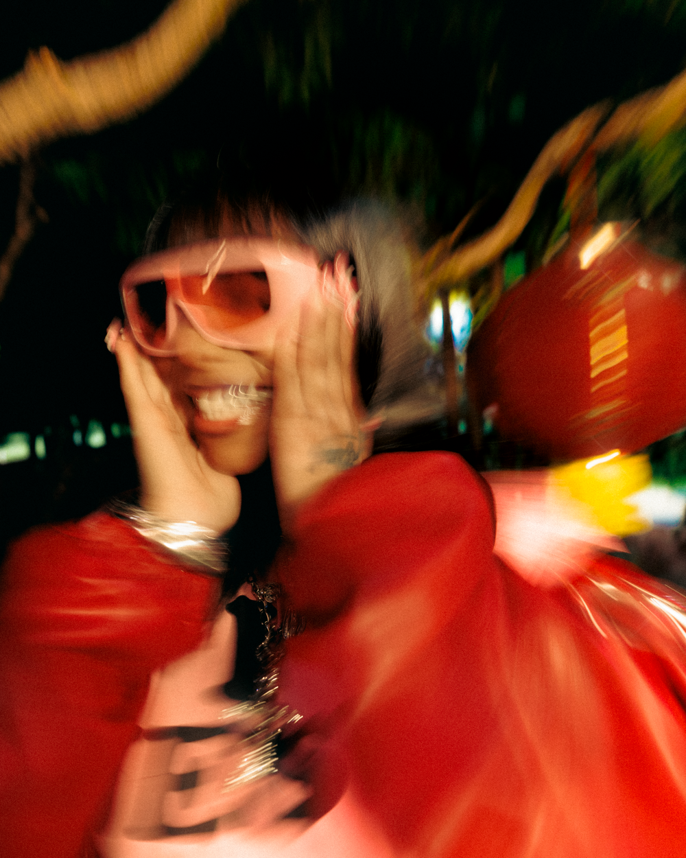 Motion-blurred figure in red clothing creates an abstract swirling effect against a dark background.
