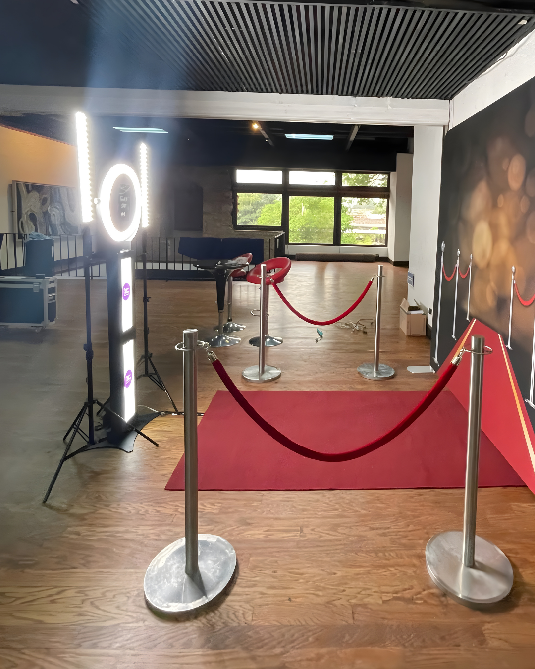 A VIP entrance setup with red velvet ropes, stanchions, and an illuminated LED light ring in an indoor venue.
