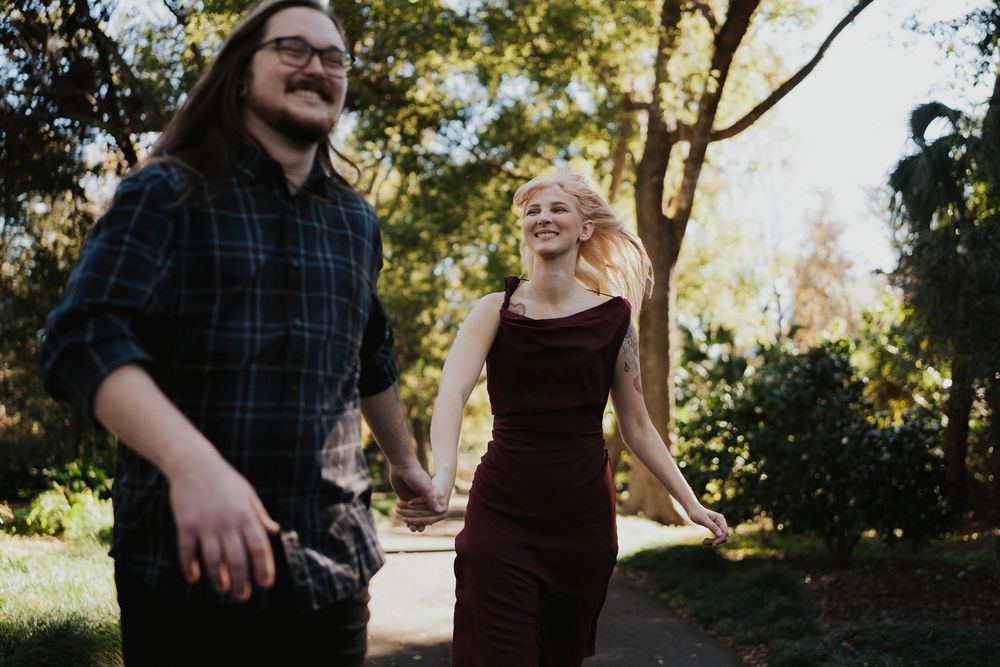 A group of people dancing and enjoying themselves in a garden setting during a sunny day.