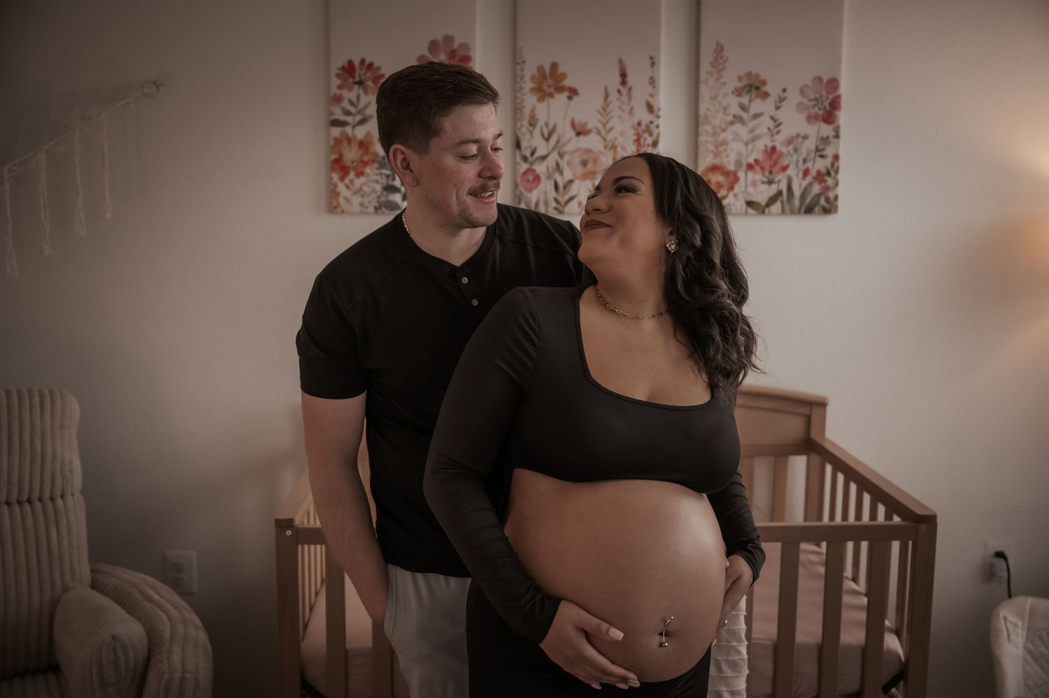 Intimate indoor maternity photoshoot with couple embracing near window light in Stafford VA.
