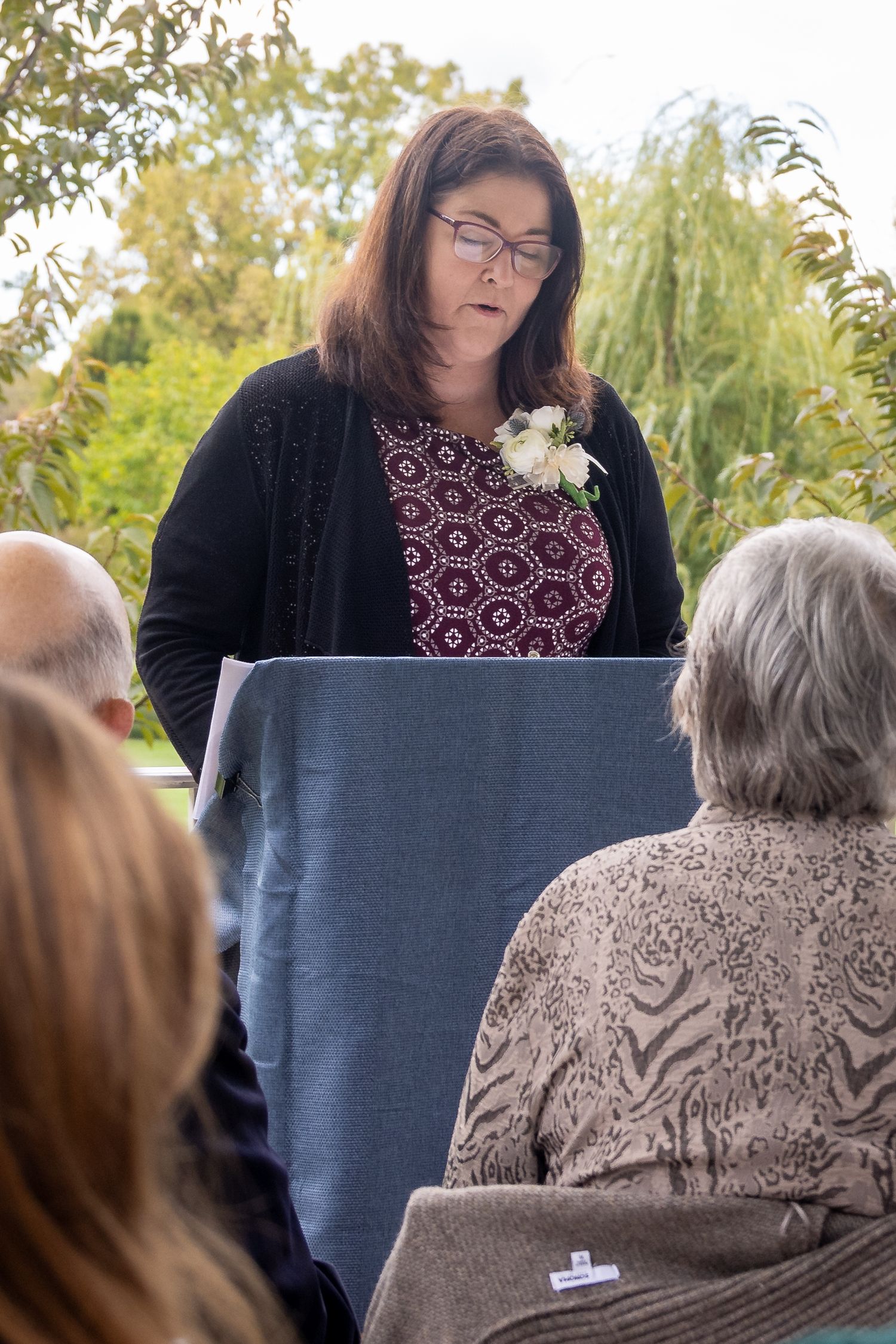 frederick maryland wedding photographer Wedding guests seated outdoors during an autumn ceremony with fall foliage in the background.