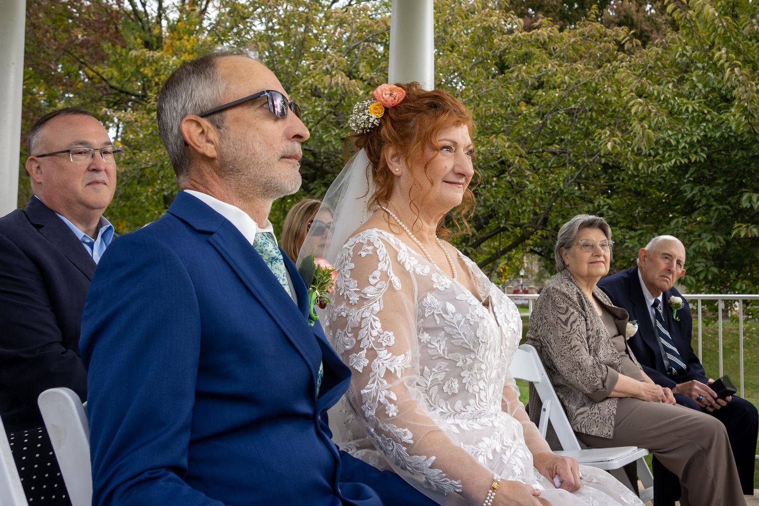 frederick maryland wedding photographer Wedding ceremony attendees seated in rows at an outdoor venue with white columns.