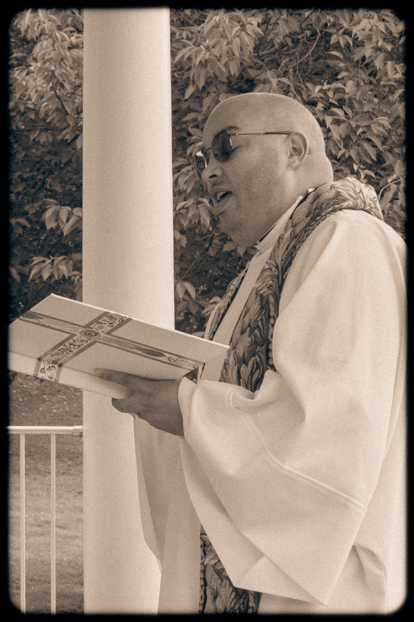 frederick maryland wedding photographer Black and white photo of officiant holding ceremony book against white column backdrop.