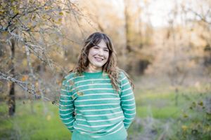 Autumn outdoor family photoshoot with warm lighting and fall foliage in the background.