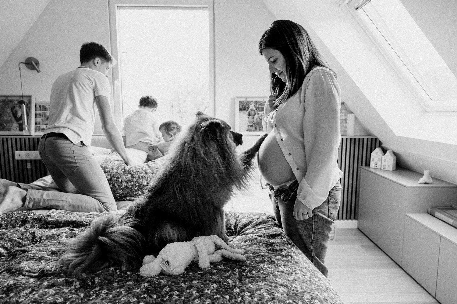 Chienne posant sa patte sur le ventre rond lors d’une seance grossesse en famille Lille attendrissante.