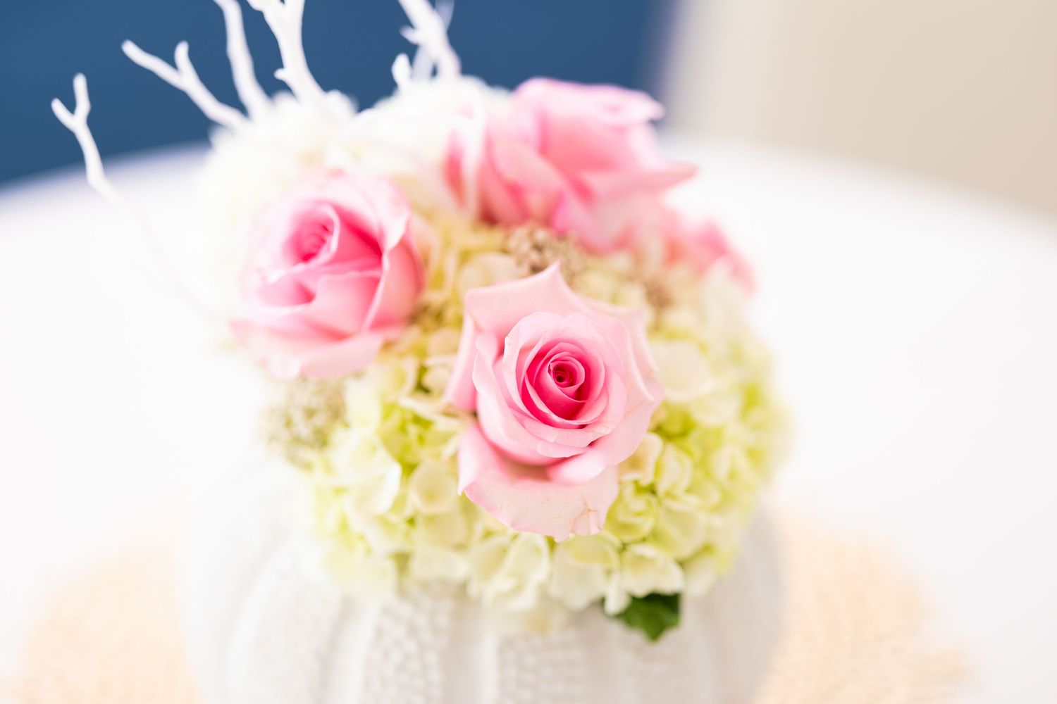 Pink roses and white hydrangeas create an elegant floral arrangement against a soft blurred background.
