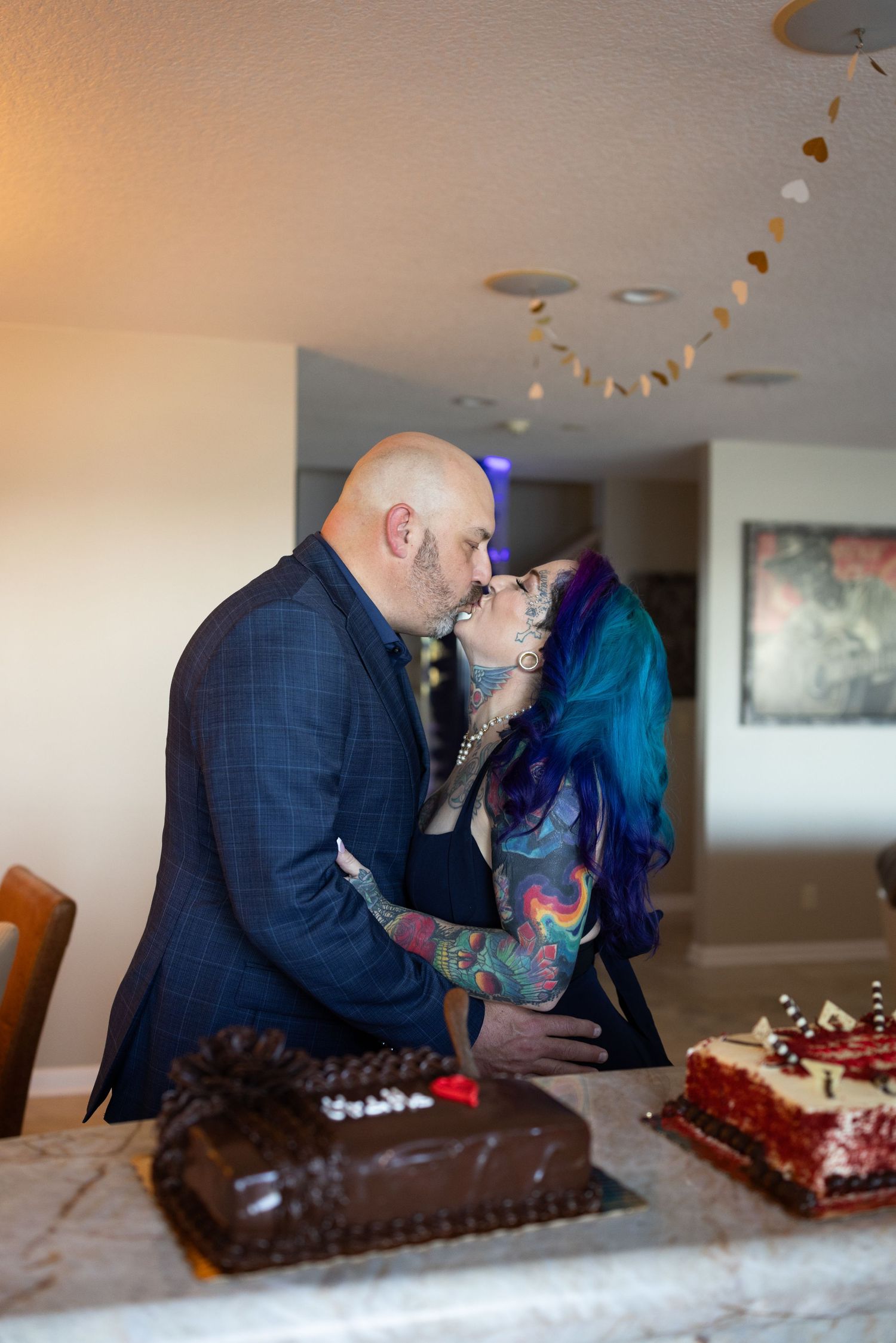 A couple shares a romantic moment while cutting their wedding cake at a reception.