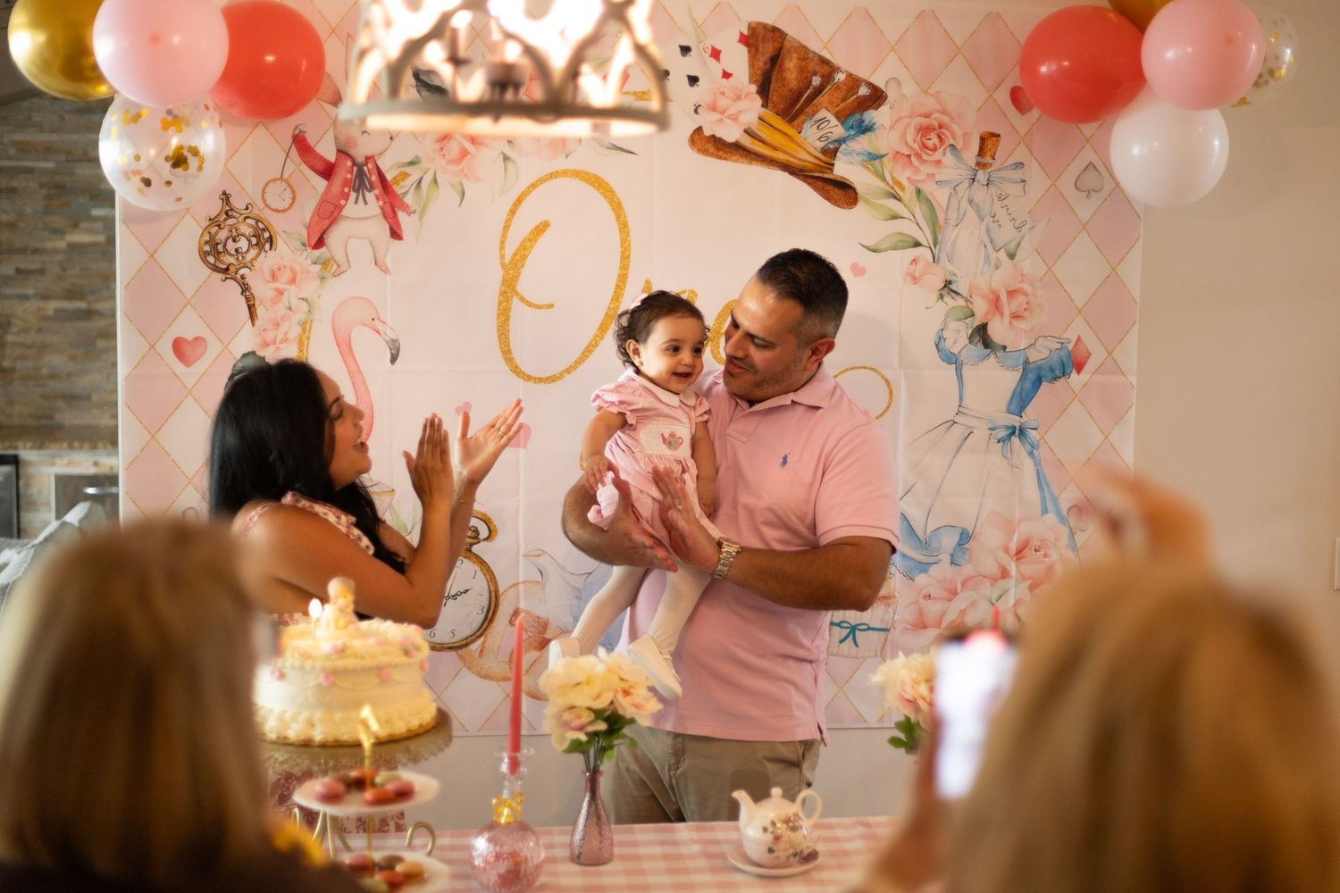 A celebration scene with balloons and pink decor at a first birthday party.