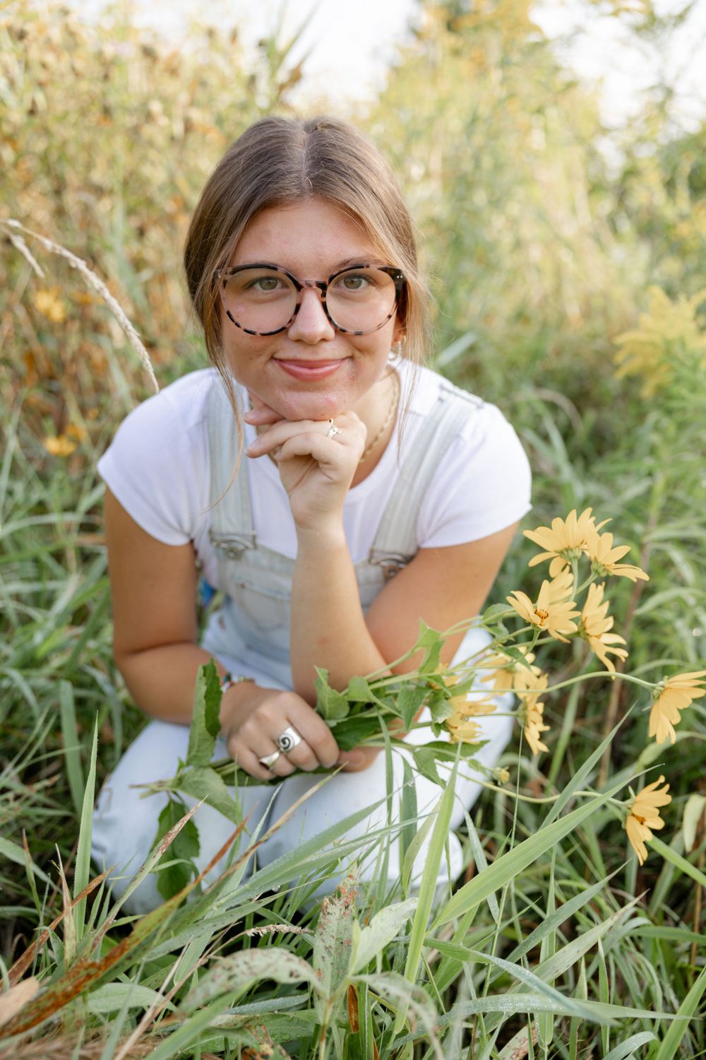 A casual portrait in a wildflower field with yellow blooms and natural summer lighting.