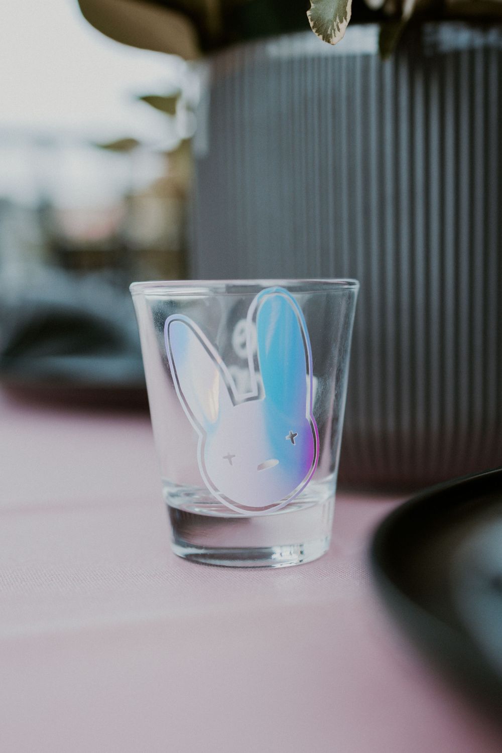 Shot glass with holographic bunny design on a pink table setting.