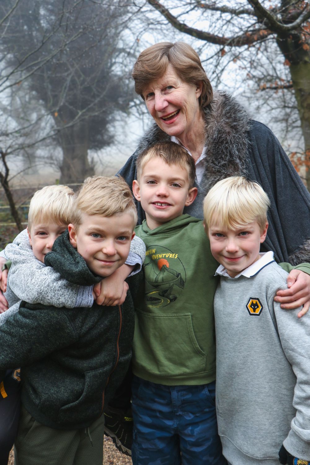 A group gathers for a casual outdoor photo on a misty winter day.
