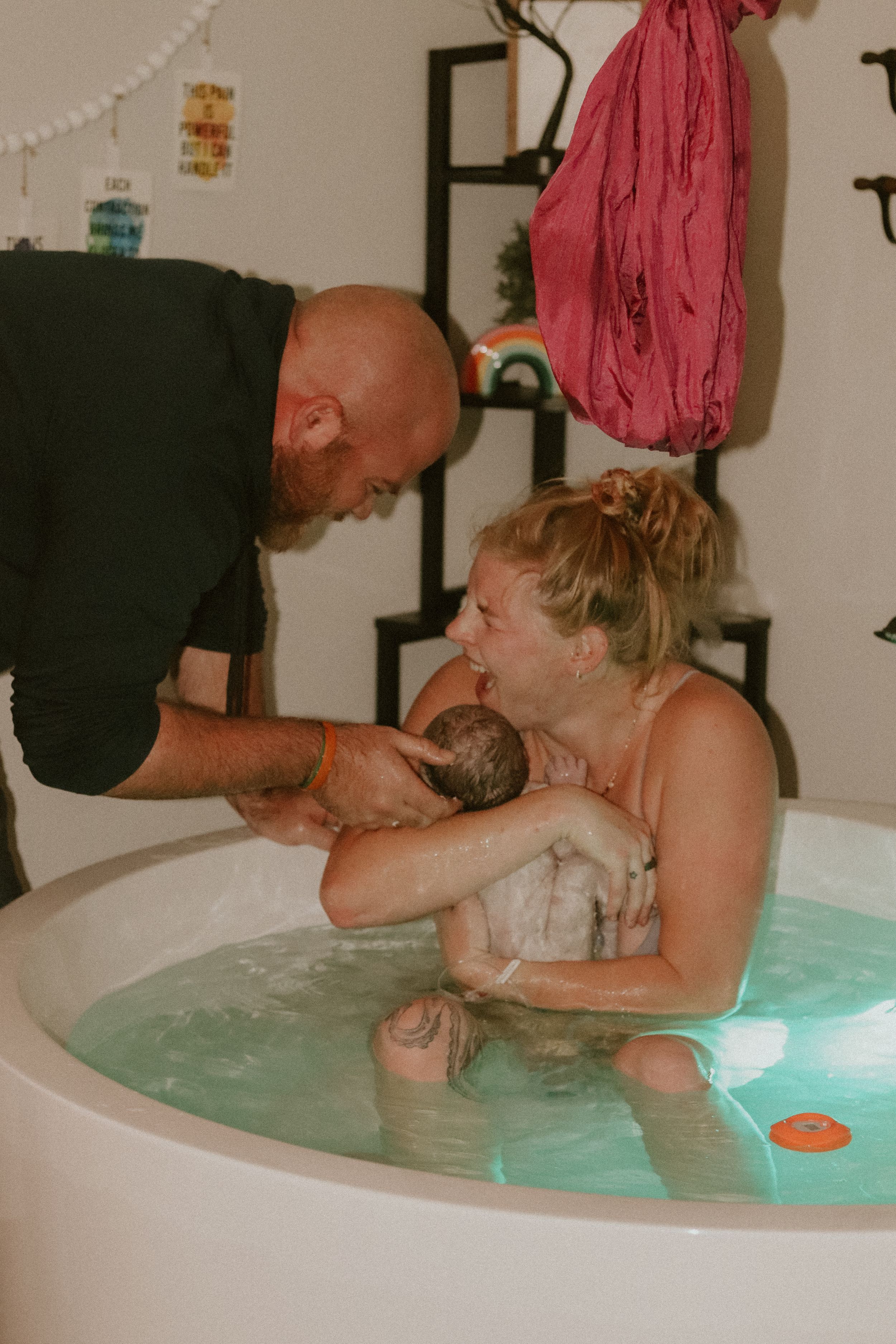 A water birth scene shows a birthing experience in a large tub with support and care during labor.
