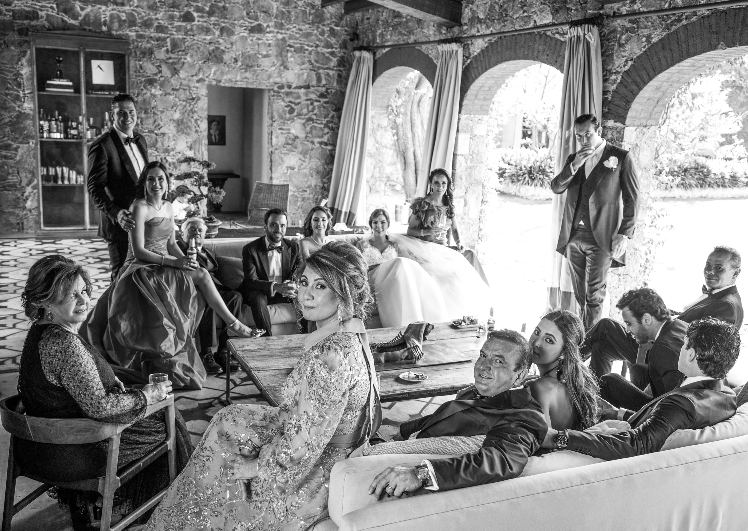 La familia de los novios descansa entre evento y evento en un día soleado. Todos lucen elegantes y alegres.
