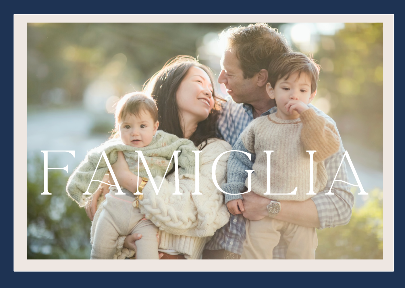 Black and white outdoor portrait of a happy family in casual attire standing together in nature.
