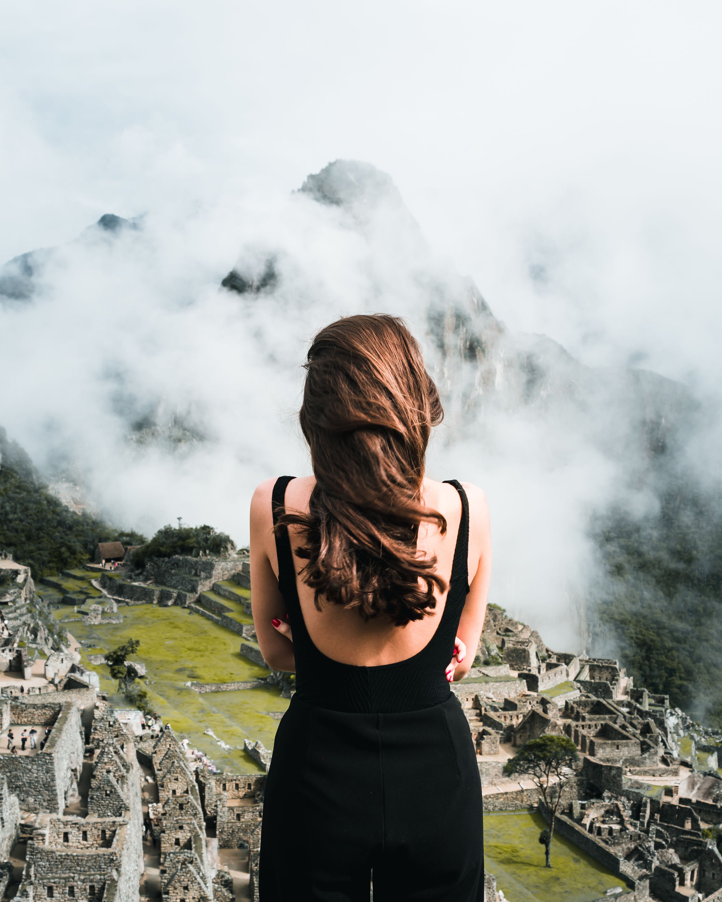 View overlooking ancient Machu Picchu ruins emerging from misty mountains.