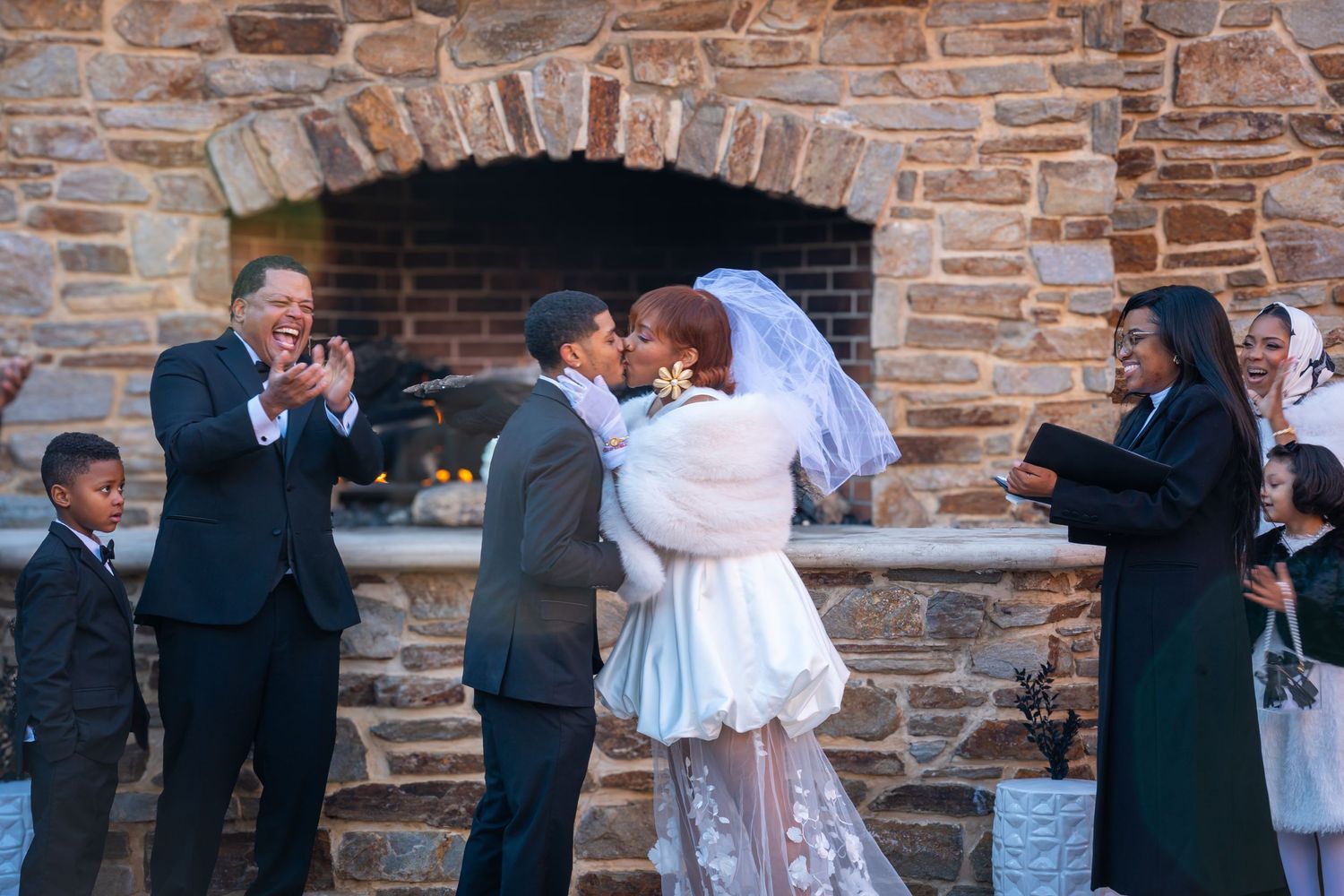 Joyful wedding ceremony scene at rustic stone venue with guests celebrating the happy moment.