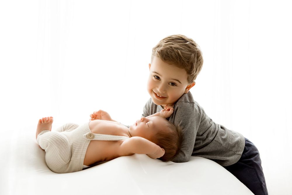 Smiling happy big brother with his newborn baby brother