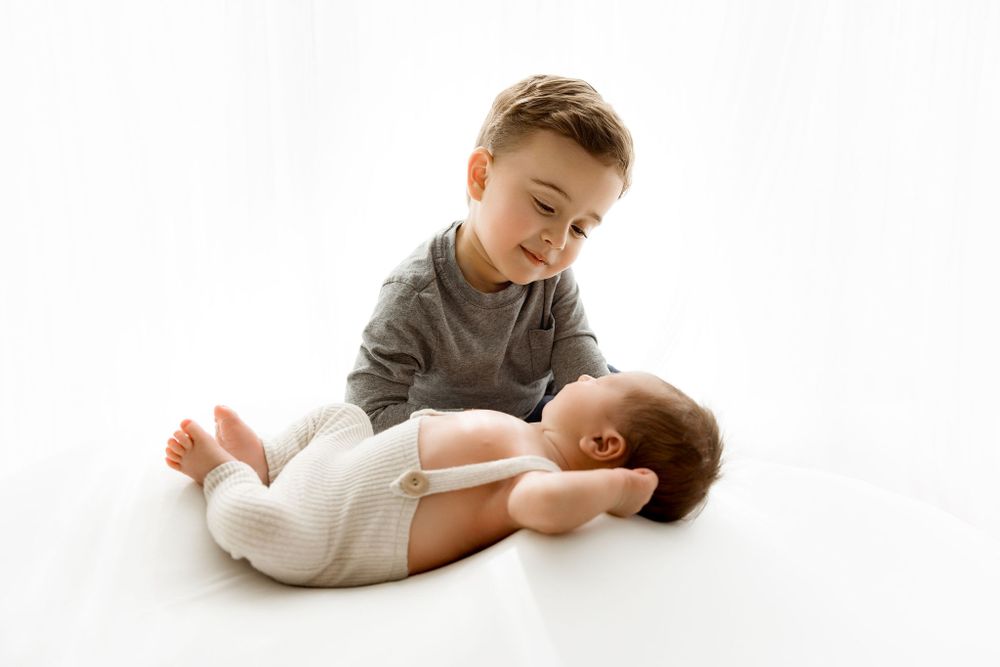 Over brother looking at his newborn baby brother