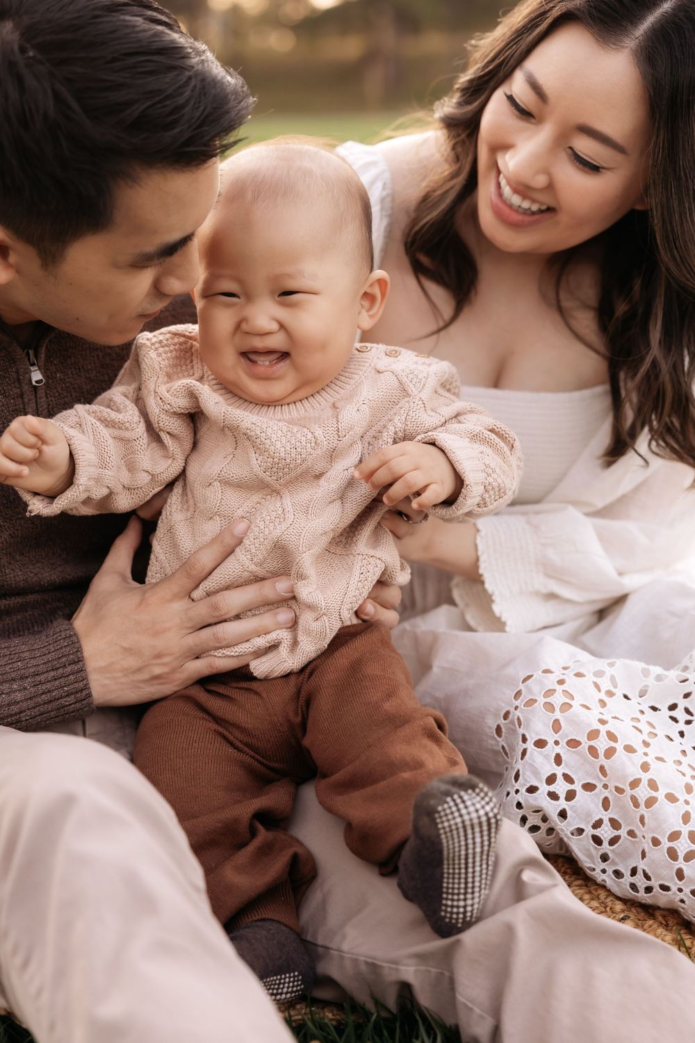 Family shares loving and playful moments during candid lifestyle photo session in neutral tones.