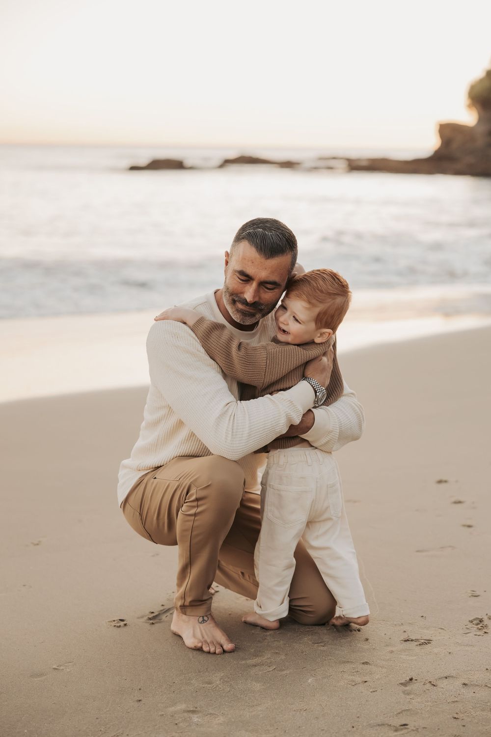 Parent and child share tender embracing moments on sandy beach at sunset creating heartwarming family photos.