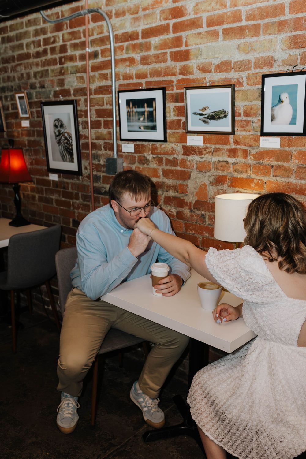 A couple shares intimate moments at a rustic brick-walled coffee shop in a sequence of casual photos.