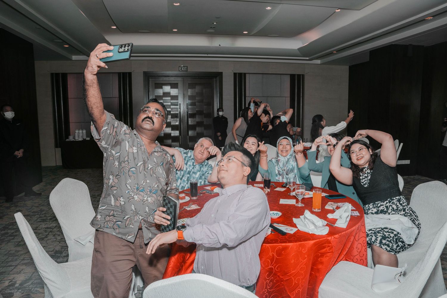 Celebratory moment during an event with attendees laughing and posing for photos.