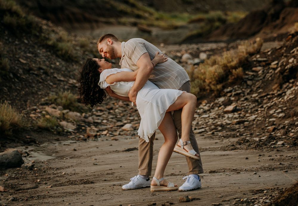 Couple shares a romantic dance pose on a rocky desert trail.