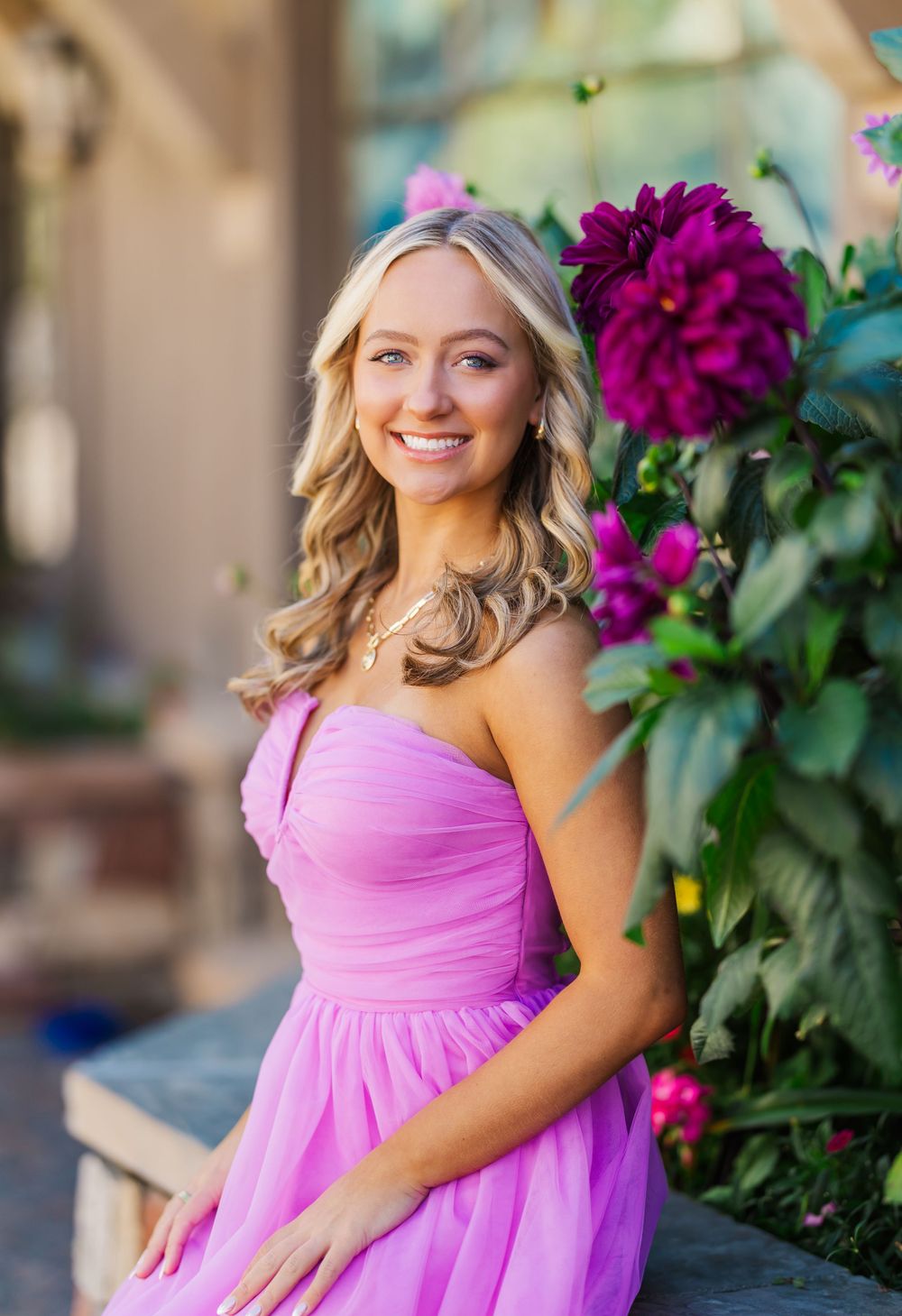 Outdoor portraits near vibrant purple flowers with someone wearing a pink formal dress.