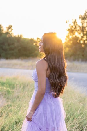 Ethereal lavender gown catches the sunset light in a dreamy meadow setting.