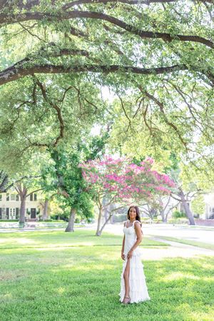 Ethereal white dress photoshoot under sprawling tree branches in a lush park.