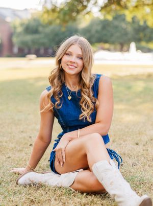 Outdoor portrait series on grass wearing a blue outfit and white boots in golden sunlight.