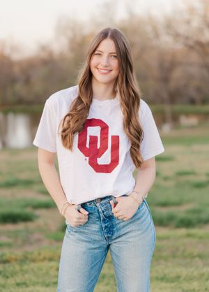 Casual outfit featuring a white OU t-shirt paired with light wash denim jeans.