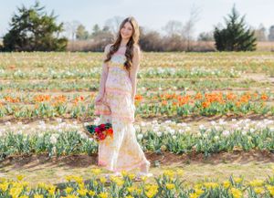 A springtime portrait series in a flowing dress among blooming yellow daffodils.