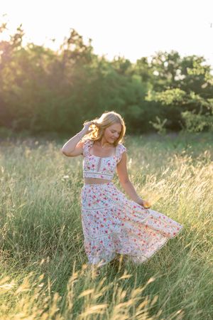 Floral dress twirling sequence captured in a sunlit meadow during golden hour.