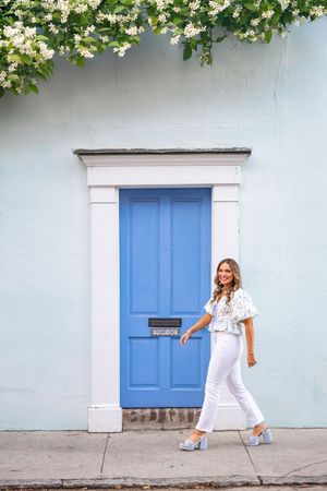 A series of photos showing someone in a white outfit posing playfully against a gray wall with a bright blue door.