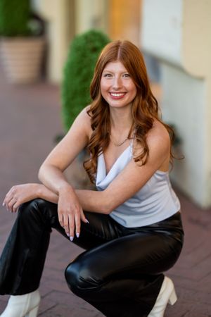 Casual portrait series featuring grey tank top and black pants on brick patio.