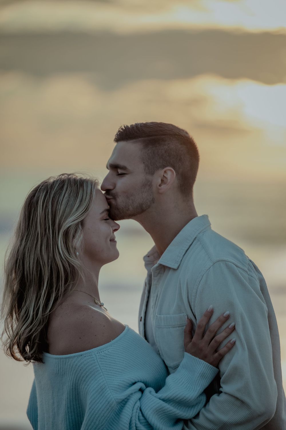 A romantic couple embraces during a sunset photoshoot, creating a dreamy and intimate series of moments.