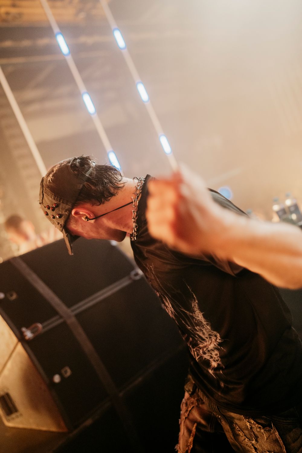DJ performing on stage with dramatic lighting and smoke effects at electronic music event.