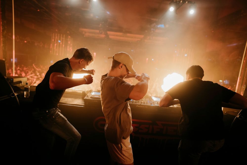 Musicians performing on stage with warm amber lighting and atmospheric fog effects.