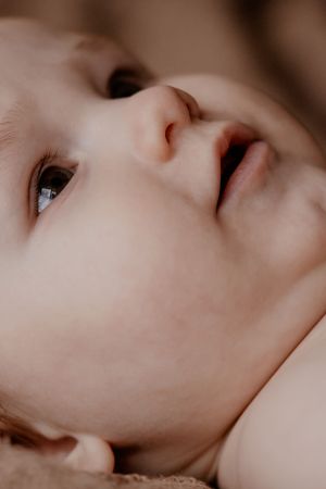 Extreme close-up van het gezicht van een baby, met stralende ogen en zachte gelaatstrekken, vastgelegd in warm licht.