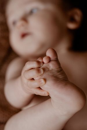 Close-up foto van kleine babyvoetjes en handjes met een zachte, onscherpe achtergrond.