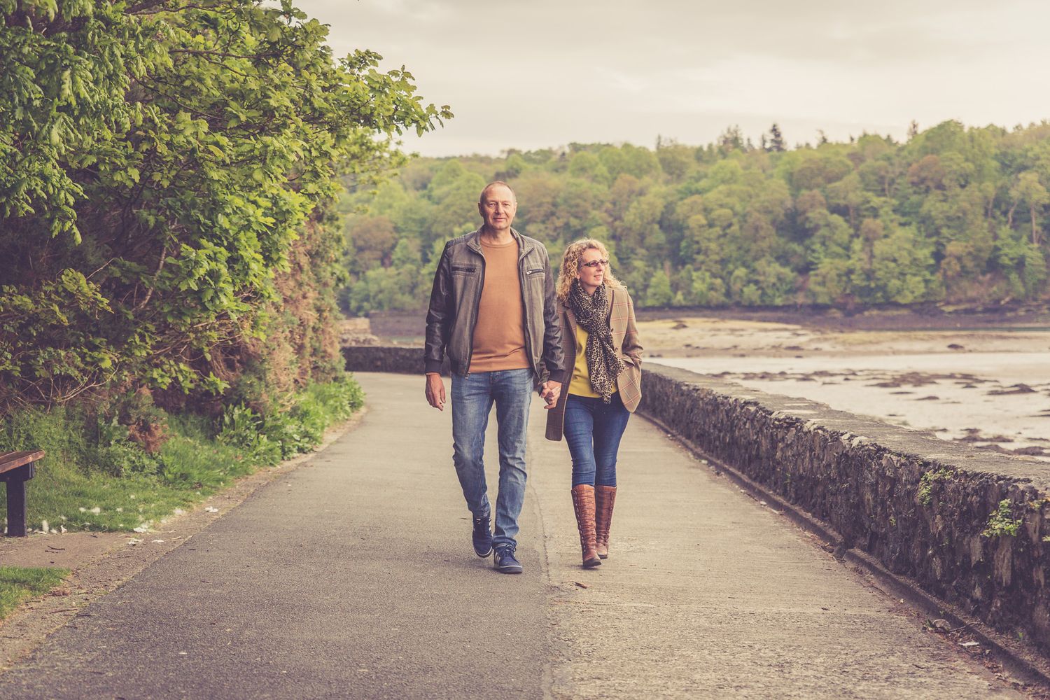 A portrait of a couple walking holding hands along the Belgian promenade, Menai Bridge. Anglesey Portrait Photographer