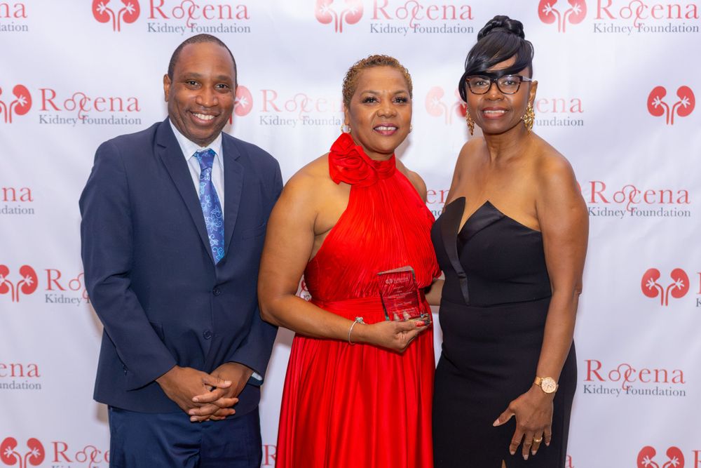 Three people at formal event with Rogena Foundation step-and-repeat backdrop.